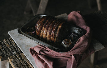 A cooked, grass fed, rolled, beef brisket with garlic and herbs.