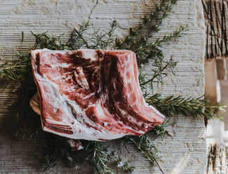 Raw Grass Fed Lamb Shoulder on a bed of rosemary