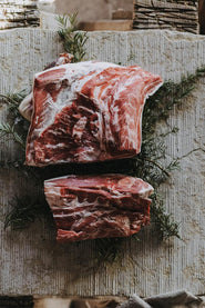 Raw Grass Fed Lamb Shoulder on a bed of rosemary