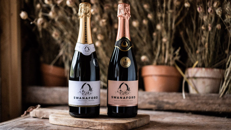 Two bottles of Swanaford sparkling wine standing on a chopping board.