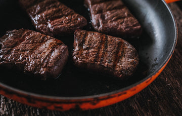 Wild venison steaks cooking in a pan