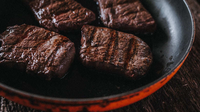 Wild venison steaks cooking in a pan
