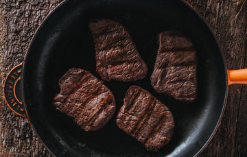 Wild venison steaks cooking in a pan