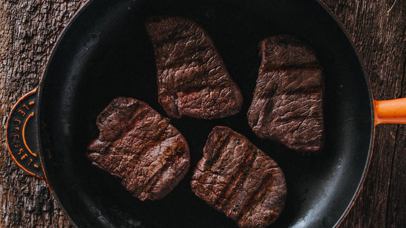 Wild venison steaks cooking in a pan